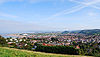 Town seen from a nearby hill with multiple houses. The sea can be seen on the left and the white tent like canopy left of centre is the Butlins centre.