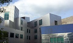 An exterior shot of a silver, uneven building