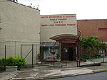 Facade of a two story school surrounded by a chain-link wire