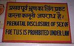 Sign in an Indian clinic reading "Prenatal disclosure of sex of foetues is prohibited under law" in English and Hindi.