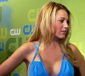 A young blonde female wearing a blue dress. The female is looking to her left.