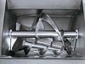 Steel mixer blades are visible inside a hopper.