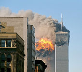 The twin towers are seen spewing black smoke and flames, particularly from the left of the two.