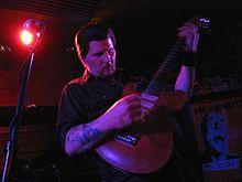 Carlson playing guitar on stage in 2009