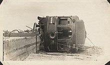 An interurban railcar lays on its side off of its tracks