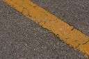 macadam - a paved surface having compressed layers of broken rocks held together with tar