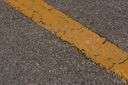tarmacadam - a paved surface having compressed layers of broken rocks held together with tar