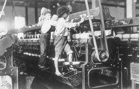 Two young boys at work in a textile mill. Before child labor laws went into effect, many companies employed young people at low wages, often exposing them to overwork, as well as hazardous and unsanitary conditions. LIBRARY OF CONGRESS
