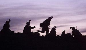 Soldiers from the 10th Mountain Division (Light Infantry), participating in the Combined Joint Task Force Mountain's Operation Anaconda, prepare to dig into fighting positions after a day of reacting to enemy fire, March 2002.jpg