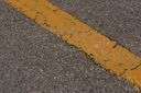 Tarmac - a paved surface having compressed layers of broken rocks held together with tar