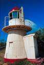 beacon light - a tower with a light that gives warning of shoals to passing ships