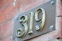 address - a sign in front of a house or business carrying the conventional form by which its location is described